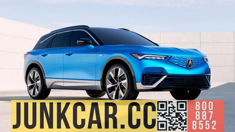 A blue 2024 Acura ZDX Type S against a concrete wall.