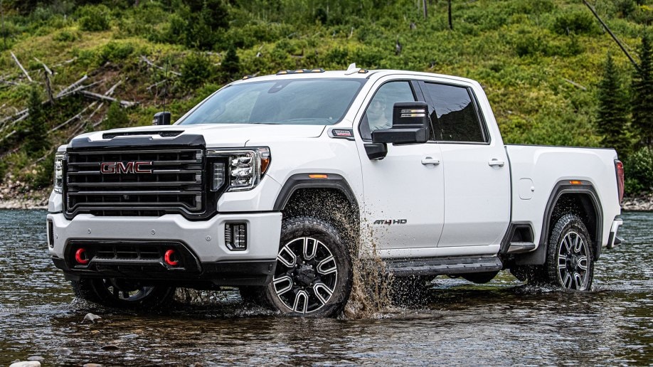 White 2021 GMC Sierra HD AT4 in a shallow riverbed