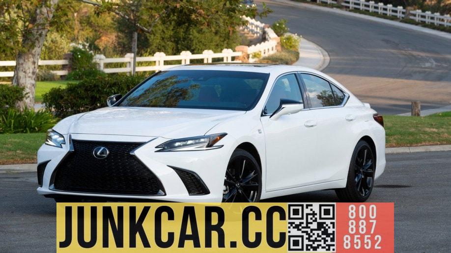 White 2023 Lexus ES 300h parked near a curved fence