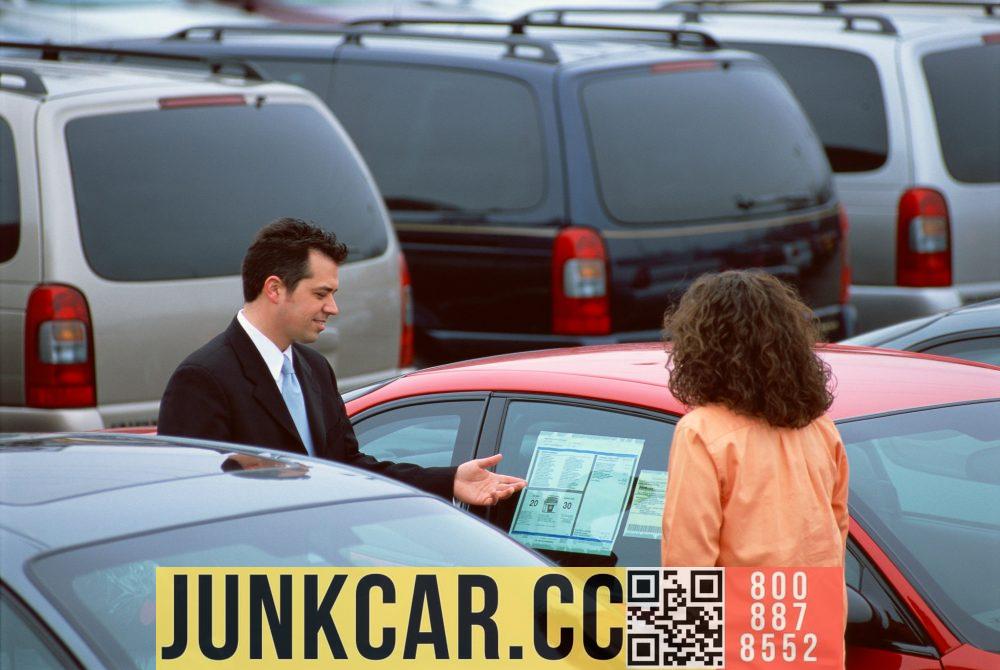 Woman looking at used cars on lot with male salesperson