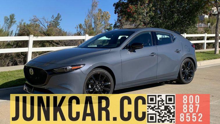 2024 Mazda 3 2.5 Turbo Premium Plus, Polymetal Gray Metallic. Near the white fence.